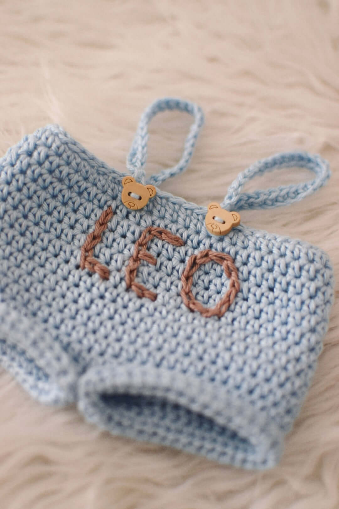 Dettaglio salopette azzurra con ricamo 